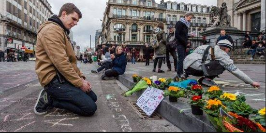 Fiori in ricordo delle vittime di Bruxelles. In apertura l'attentato all'aeroporto e sullo sfondo le immagini dei tre terroristi